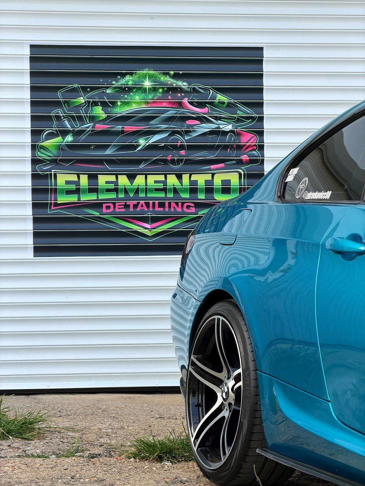 Logo Elemento Detailing na zidu i plavi automobil
